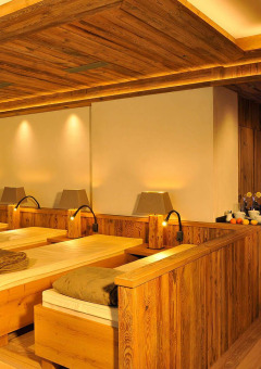 Ontspanningsruimte met houten ligbedden en sfeerverlichting bij Camping Seeblick Toni, Tirol, Oostenrijk.