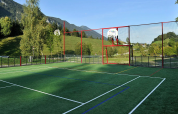 Campo sportivo con canestro da basket e rete al Camping Seeblick Toni nel Tirolo, Austria, circondato da colline.