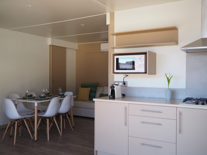 Moderne keuken en eetgedeelte in Bungalow Quermany bij Camping Mas Patoxas, Spanje, met lichte inrichting.