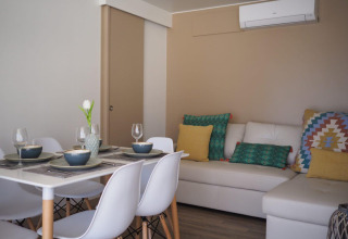 Zona pranzo e soggiorno del Bungalow Quermany, Camping Mas Patoxas, Spagna, con arredo moderno.