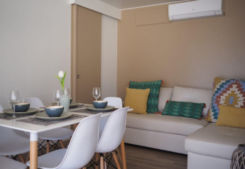 Zona pranzo e soggiorno del Bungalow Quermany, Camping Mas Patoxas, Spagna, con arredo moderno.