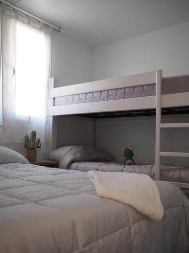 Kamer in Bunaglow Quermany, Camping Mas Patoxas, met eenpersoonsbed, stapelbed en knuffel.