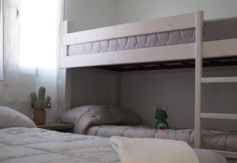 Chambre du Bunaglow Quermany, Camping Mas Patoxas, avec lit simple, lit superposé et peluche.