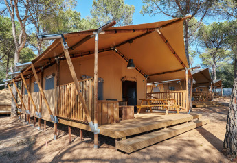 Safari-teltet Glamping Tramuntana ved Camping Mas Patoxas i Spanien, omgivet af fyrretræer og sollys.