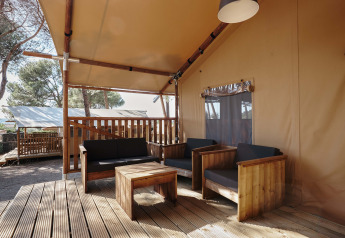 Zona lounge su terrazza in legno presso la tenda safari Glamping Tramuntana, Camping Mas Patoxas, Spagna.