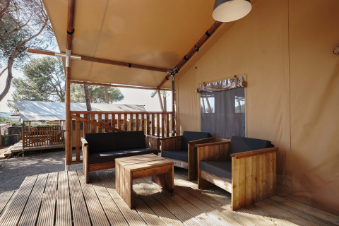 Zona lounge su terrazza in legno presso la tenda safari Glamping Tramuntana, Camping Mas Patoxas, Spagna.