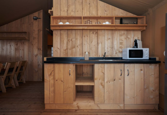 Angolo cucina nella tenda safari Glamping Tramuntana al Camping Mas Patoxas in Spagna, tutto in legno.