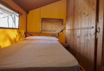 Interior view of a cozy bedroom inside a safari tent at Glamping Tramuntana, Camping Mas Patoxas, Spain.