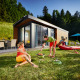 To personer hygger sig ved grill foran et moderne Panorama Chalet omgivet af natur og grønne bakker.