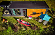 Aerial view of Panorama Chalets featuring a deck, kayak, lawn chairs, and umbrella in a grassy area.
