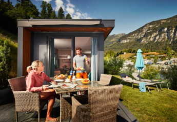 Twee personen genieten van ontbijt buiten bij Panorama Chalets met uitzicht op bergen en gezelligheid.