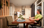 Twee mensen genieten van koffie in de lichte keuken van Studio tiny house op Camping Seeblick Toni, Oostenrijk.