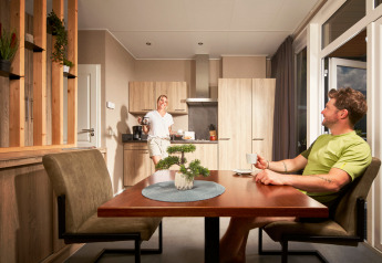 Due persone si godono il caffè nella cucina luminosa della tiny house Studio al Camping Seeblick Toni in Austria.