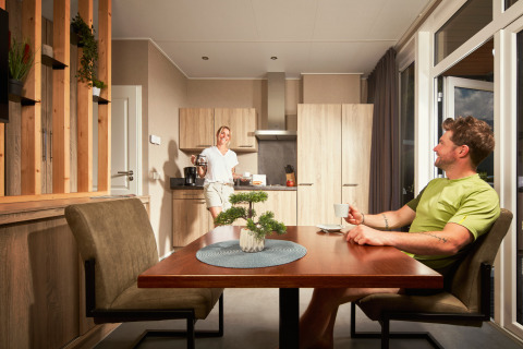 Twee personen drinken koffie in de gezellige keuken van Studio tiny house op Camping Seeblick Toni, Oostenrijk.