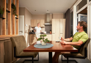 Twee personen drinken koffie in de gezellige keuken van Studio tiny house op Camping Seeblick Toni, Oostenrijk.