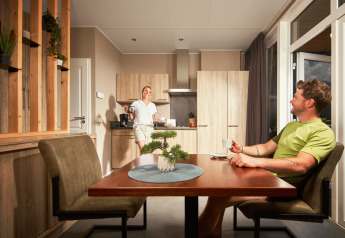 Due persone si godono il caffè nella cucina luminosa della tiny house Studio al Camping Seeblick Toni in Austria.