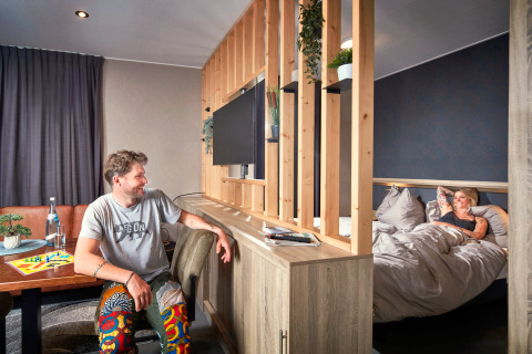 Knusse studio bij Camping Seeblick Toni in Oostenrijk, met een stel dat ontspant in een moderne tiny house.