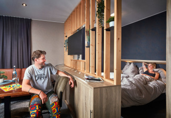 Gezellige studio in Camping Seeblick Toni, Oostenrijk, waar een koppel ontspant in een moderne tiny house.