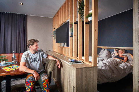 Acogedor estudio en Camping Seeblick Toni, Austria, con una pareja relajándose en una pequeña casa moderna.