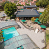 Aerial view of Huttopia Versailles holiday park with covered pool, sun terrace, and outdoor seating area.