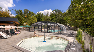 Außenpoolbereich mit überdachtem Schwimmbecken und Whirlpool im Huttopia Versailles, Île de France, Frankreich.