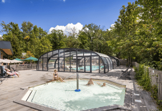 Piscines extérieures et vacanciers détendus dans un cadre boisé à Huttopia Versailles, Île de France, France.