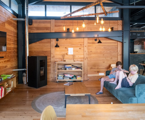 Zwei Kinder entspannen sich in einer gemütlichen Holzhütte im Ferienpark Huttopia Versailles, Frankreich.