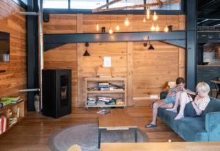 Two children relax in a cozy wooden cabin at Huttopia Versailles holiday park near Paris, France.