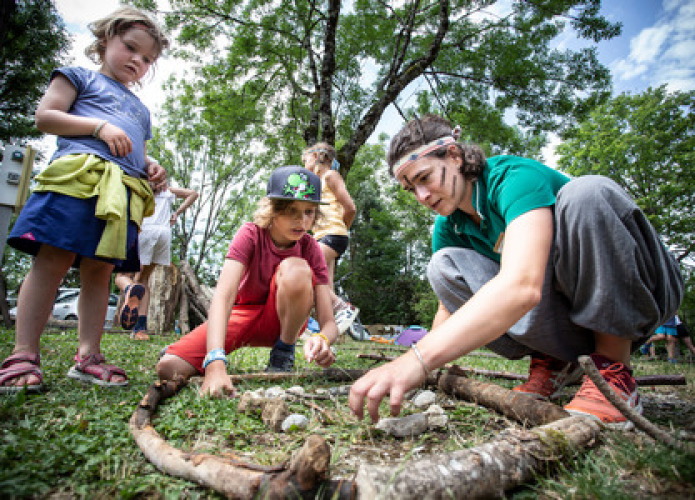 Enfants et adulte créent une activité nature en plein air à Huttopia Versailles, Île de France.