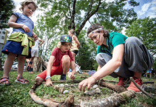 Children and an adult enjoy outdoor nature activities at Huttopia Versailles holiday park in Île de France.