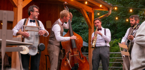 Una banda de jazz actuando al aire libre por la tarde en Huttopia Versailles en Île de France, Francia.