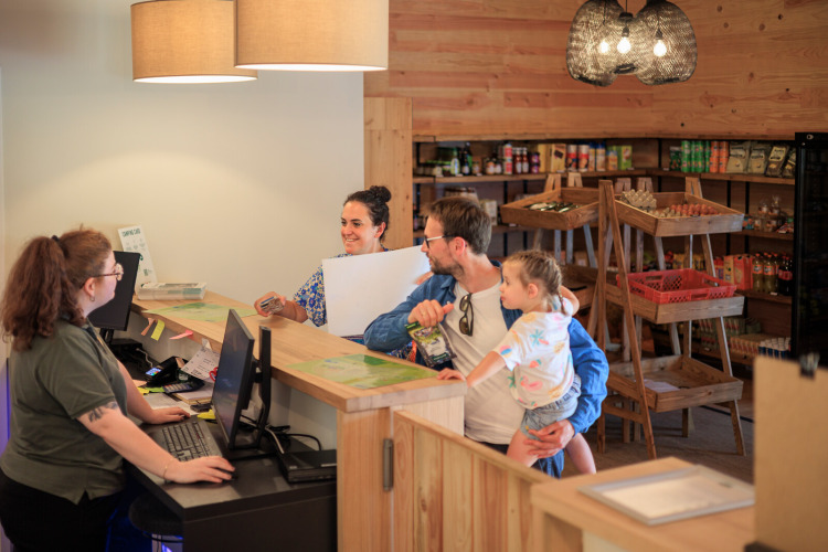 Family checks in at the reception desk of a shop at Huttopia De Meinweg holiday park in Limburg, Netherlands.