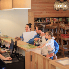 Familia se registra en la recepción de una tienda en Huttopia De Meinweg en Limburg, Países Bajos.