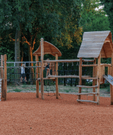 Parque infantil con estructura de madera y tobogán en Huttopia De Meinweg, Limburg, Países Bajos.