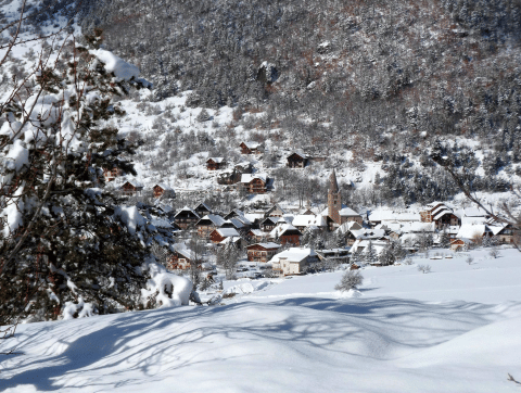 Snowy view of Les Chalets Huttopia de Vallouise holiday park in Provence-Alpes-Côte d’Azur, France in winter.