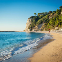 Playa de arena dorada y acantilados verdes cerca de Sassoferrato, en la región de Las Marcas, Italia.