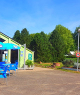 Outdoor café area with blue chairs and umbrellas at Camping Seasonova Le Martinet in Centre-Val de Loire, France.