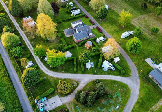 Luftfoto af Camping Seasonova Le Martinet i Centre-Val de Loire, Frankrig med campingvogne og grønne områder.