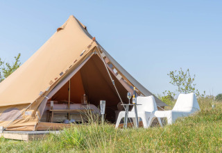 Tenda glamping con sedie all'aperto al Little Canvas Escape, parco vacanze in Frisia, Paesi Bassi.