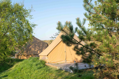 Due tende da glamping tra alberi e prato al Little Canvas Escape, un villaggio turistico in Frisia, Paesi Bassi.