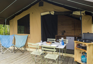 Safari tent Toile&Bois tent Sweet at Huttopia La Plage Blanche, France, featuring patio seating and a camp kitchen.