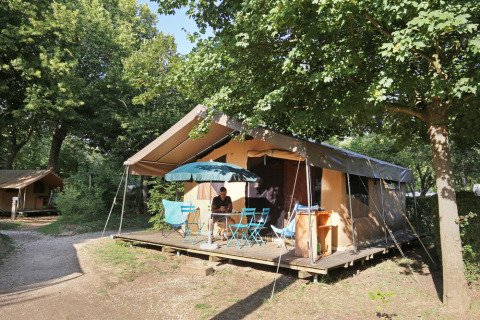Tente safari Toile&Bois Sweet à Huttopia La Plage Blanche, France, avec terrasse et meubles de jardin.