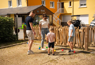 Eine Familie spielt Boule auf einem Spielplatz im Ferienpark Camping Kost Ar Moor in der Bretagne, Frankreich.