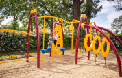 Parco giochi con struttura colorata e bambini, punto forte del Camping Kost Ar Moor in Bretagna, Francia.