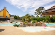 Buitenzwembad met tropisch decor op Camping Kost Ar Moor vakantiedomein in Bretagne, Frankrijk.
