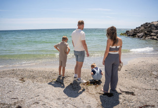Een familie geniet van het uitzicht op het strand bij Camping Kost Ar Moor in Bretagne, Frankrijk.