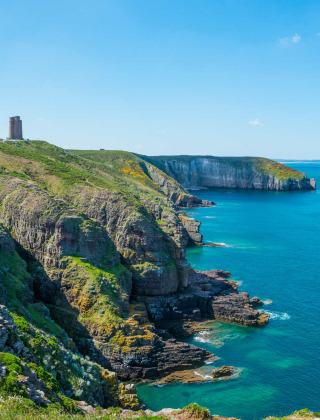 Impresionantes acantilados y faro junto al mar azul en Mousterlin - Fouesnant, Bretaña, Francia.