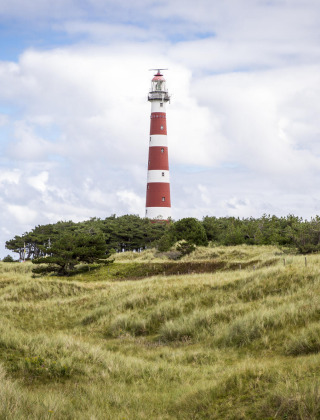 Un faro de rayas rojas y blancas se alza sobre una colina cubierta de hierba cerca de Nes, Friesland.