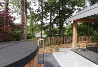 Vue depuis l'Eco Cottage avec jacuzzi extérieur et terrasse à De Thijmse Berg, entouré de verdure, Pays-Bas.