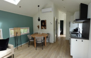 Moderne stue og køkken i Eco Cottage med grøn accentvæg på De Thijmse Berg, Nederlandene.